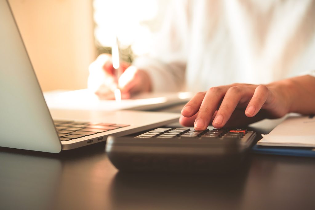 Close up of business woman accountant hand using calculator